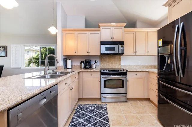 a kitchen with granite countertop a sink stainless steel appliances and cabinets