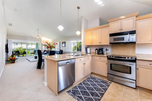 a kitchen with stainless steel appliances granite countertop a sink a stove and a refrigerator