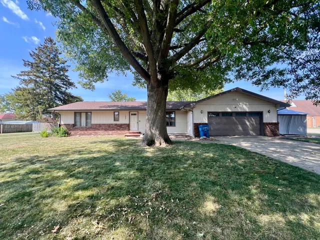 a view of house with backyard and a garden