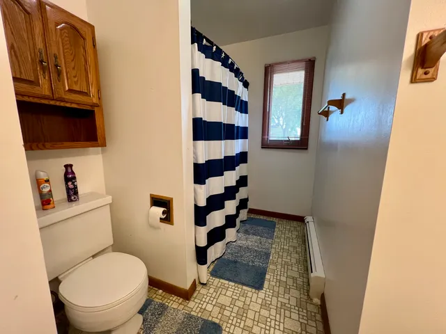 a bathroom with a toilet and a shower