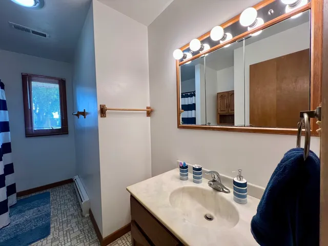 a bathroom with a sink vanity and a mirror