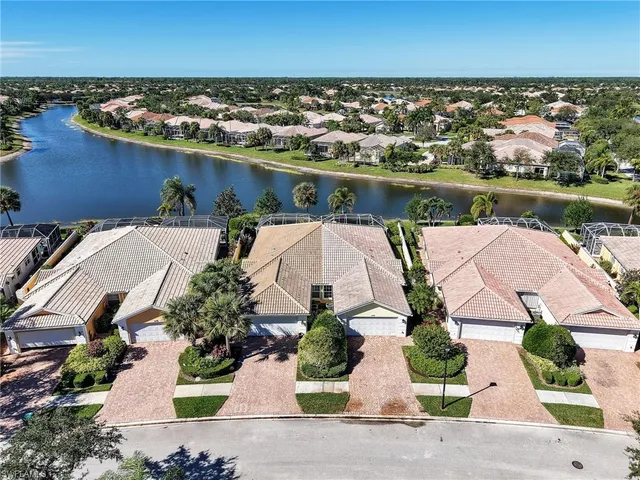 an aerial view of a house with a yard and lake view