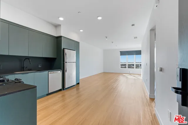 a kitchen with stainless steel appliances a refrigerator and a stove top oven