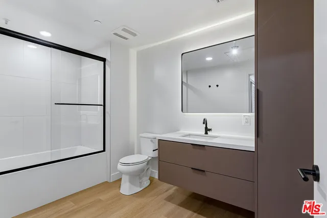 a bathroom with a sink a toilet and a large mirror