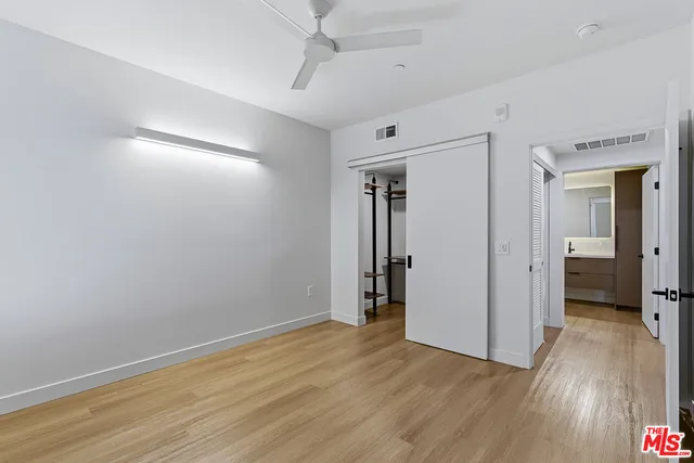 an empty room with wooden floor and a hallway