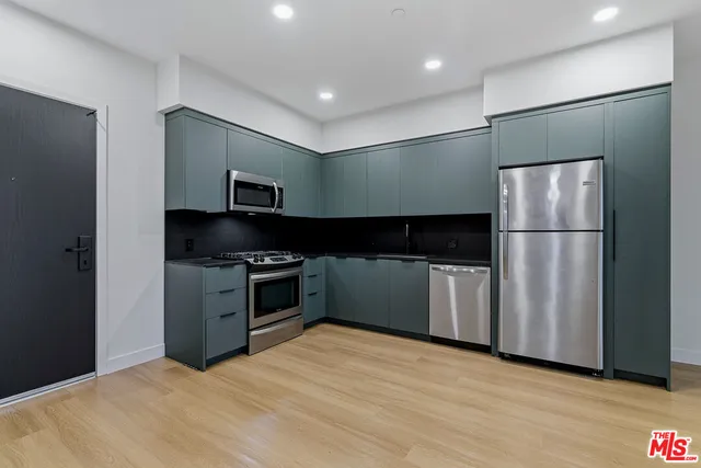 a kitchen with a refrigerator and a stove top oven