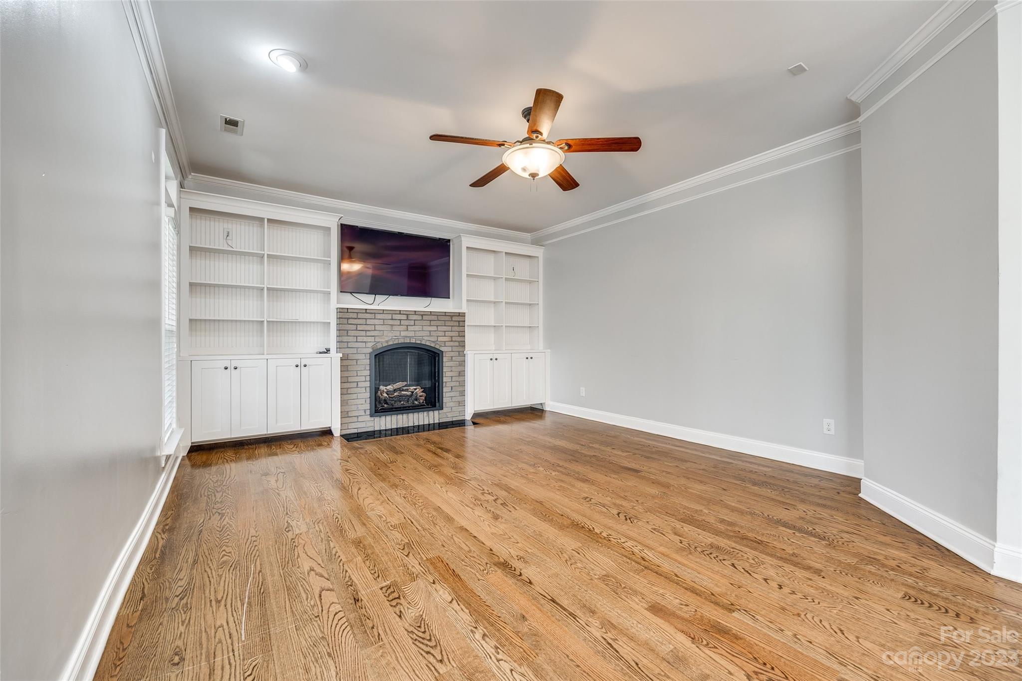 16420 Woolwine Road Charlotte, NC 28278 - Photo 7 of 41 a view of empty room with wooden floor fireplace and fan