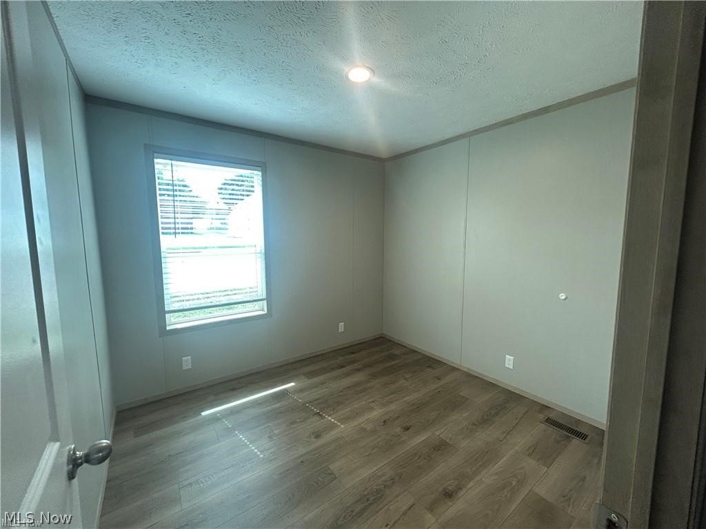 252 Front Street Philo, OH 43771 - Photo 13 of 17 Spare room with a textured ceiling and wood finished floors