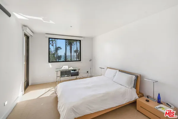 a bedroom with a bed and a painting on the wall