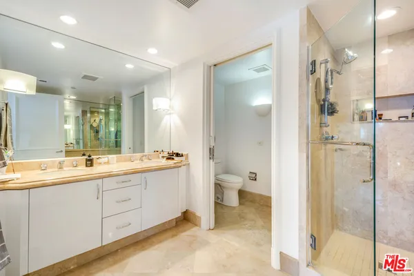 a bathroom with a double vanity sink mirror and shower