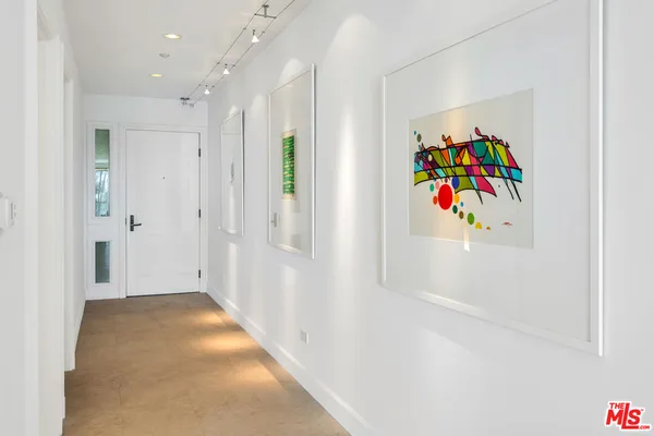 a hallway with painting and refrigerator
