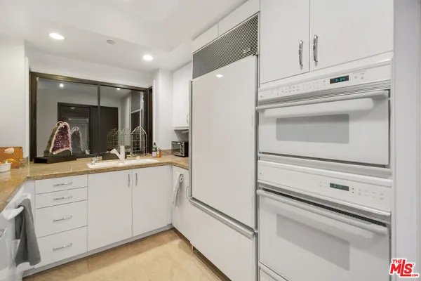a kitchen with white cabinets and white appliances