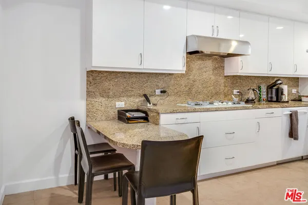 a kitchen with a white cabinets and chairs