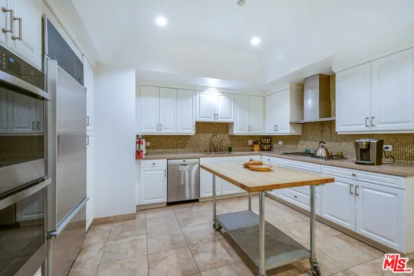 a kitchen with a refrigerator a stove top oven a sink and cabinets