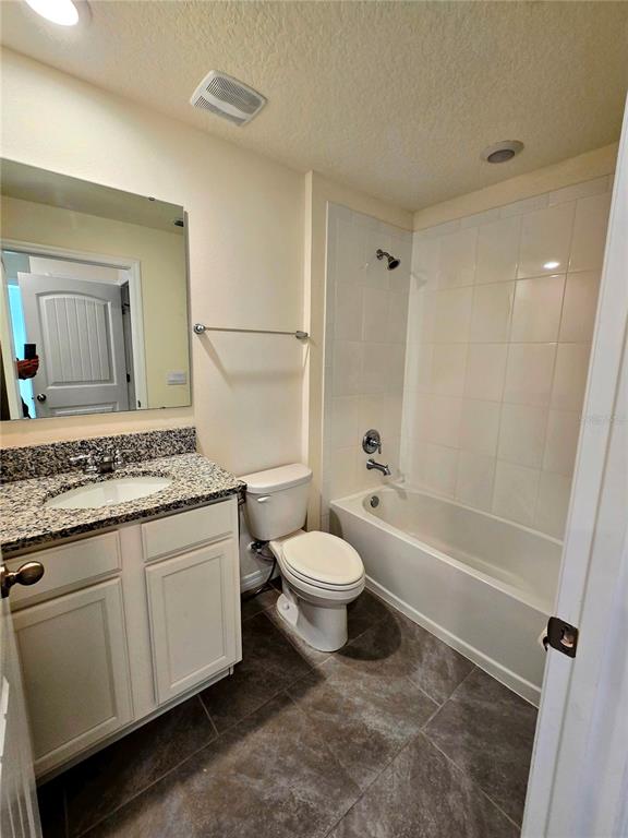17101 Water Spring Boulevard Winter Garden, FL 34787 - Photo 18 of 29 a bathroom with a granite countertop toilet a sink and a bathtub