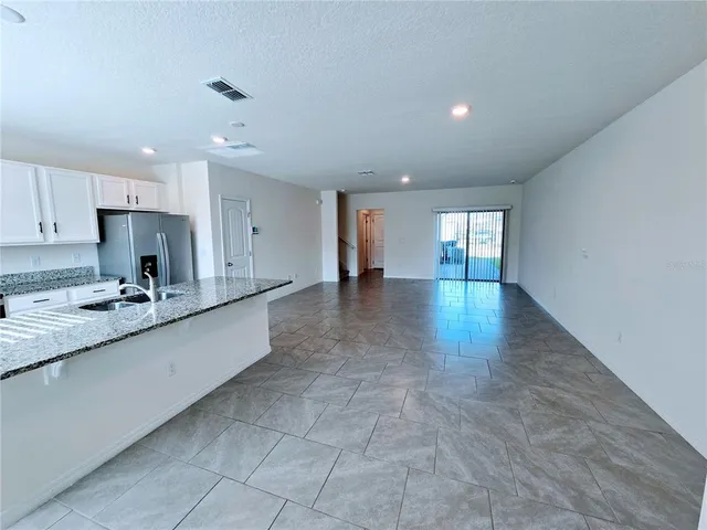 a large kitchen with stainless steel appliances granite countertop a sink and cabinets