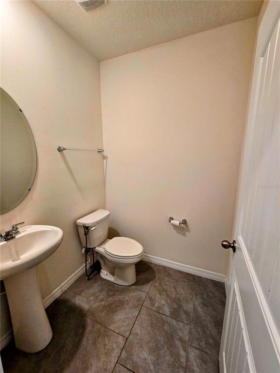 17101 Water Spring Boulevard Winter Garden, FL 34787 - Photo 9 of 29 a white toilet sitting next to a bathroom sink