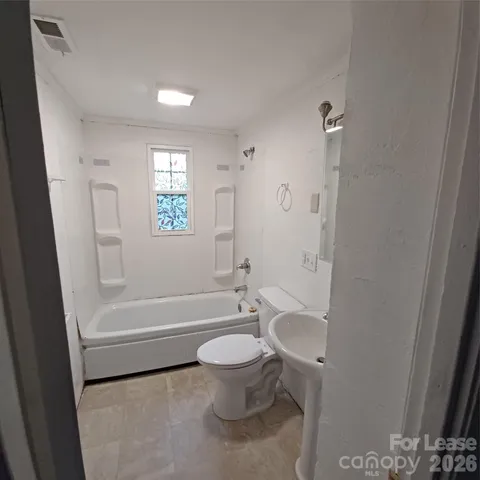a bathroom with a toilet a sink and bathtub