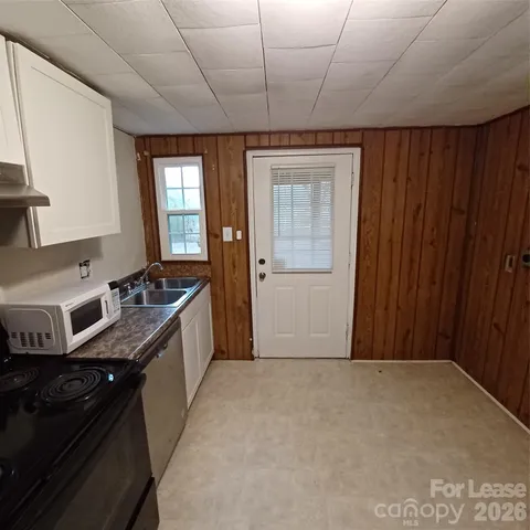 a kitchen with granite countertop a sink stove and cabinets