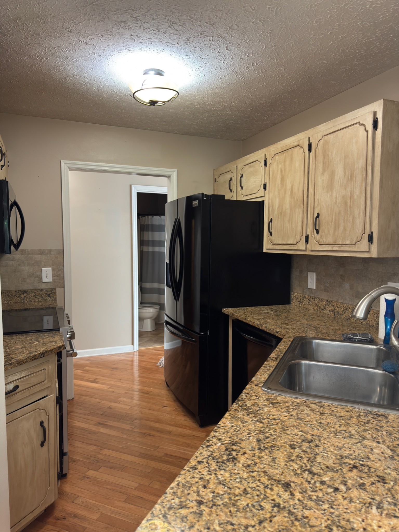 3594 Oak Grove Road Red Boiling Springs, TN 37150 - Photo 24 of 33 a kitchen with granite countertop a refrigerator and a sink