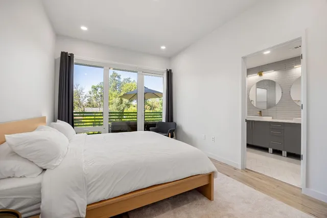 a bed sitting in a spacious bedroom next to a window