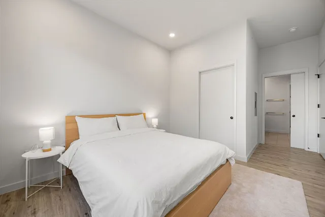 a large white bedroom with bed and closet