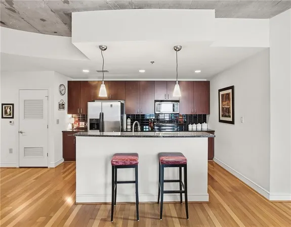 a kitchen with stainless steel appliances granite countertop a sink refrigerator and microwave