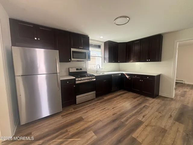 a kitchen with kitchen island stainless steel appliances a refrigerator and a sink