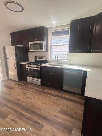 a kitchen with stainless steel appliances granite countertop a sink and a stove