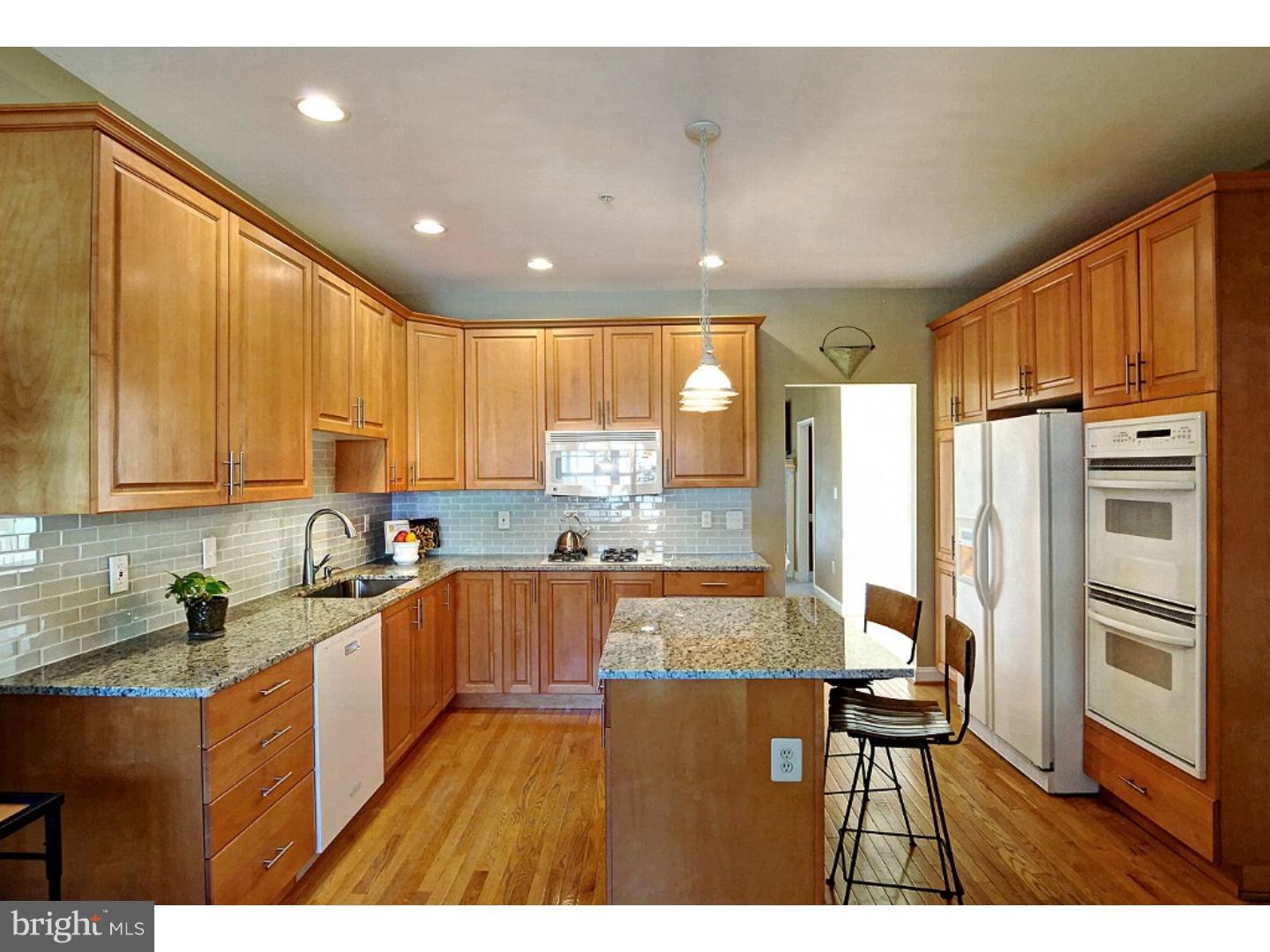 1113 Brian's Way Wayne, PA 19087 - Photo 9 of 25 a kitchen with stainless steel appliances granite countertop a refrigerator a sink dishwasher a stove with wooden cabinets and floor