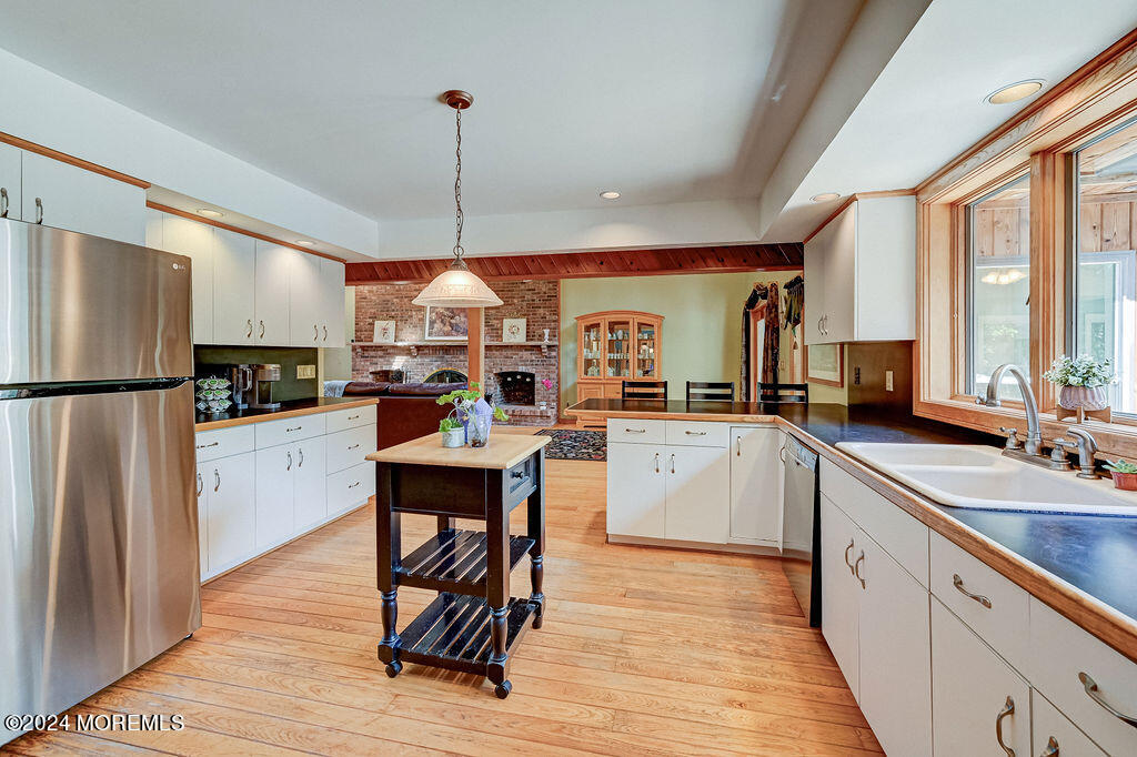 290 Easy Street Howell, NJ 07731 - Photo 11 of 43 a kitchen with stainless steel appliances granite countertop a refrigerator a sink dishwasher a stove and white countertops with wooden floor