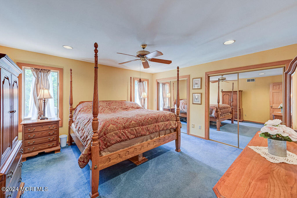 290 Easy Street Howell, NJ 07731 - Photo 27 of 43 a spacious bedroom with a bed and a chandelier