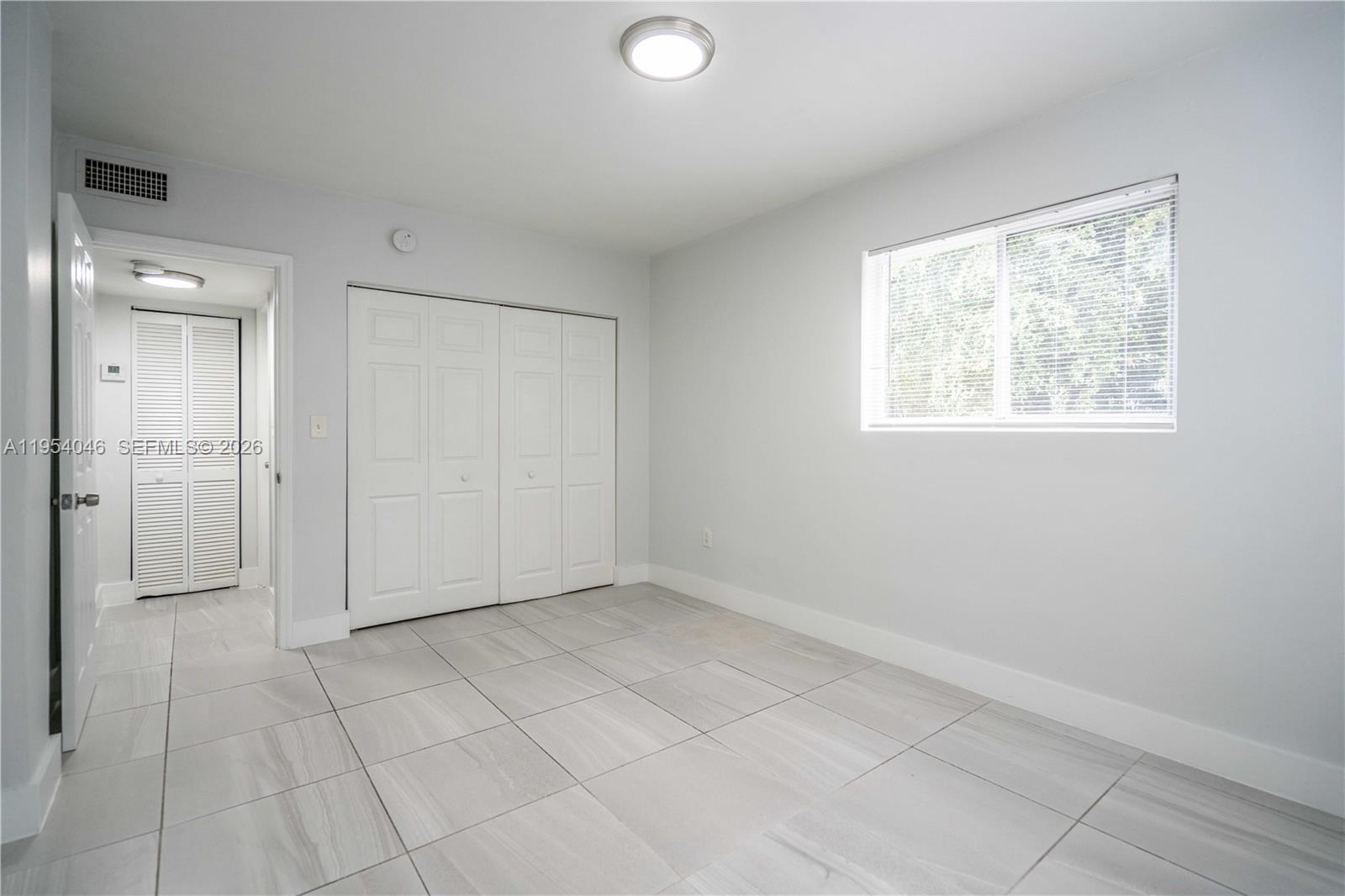 465 Northeast 59th Street, Unit 12 Miami, FL 33137 - Photo 11 of 17 an empty room with windows and closet