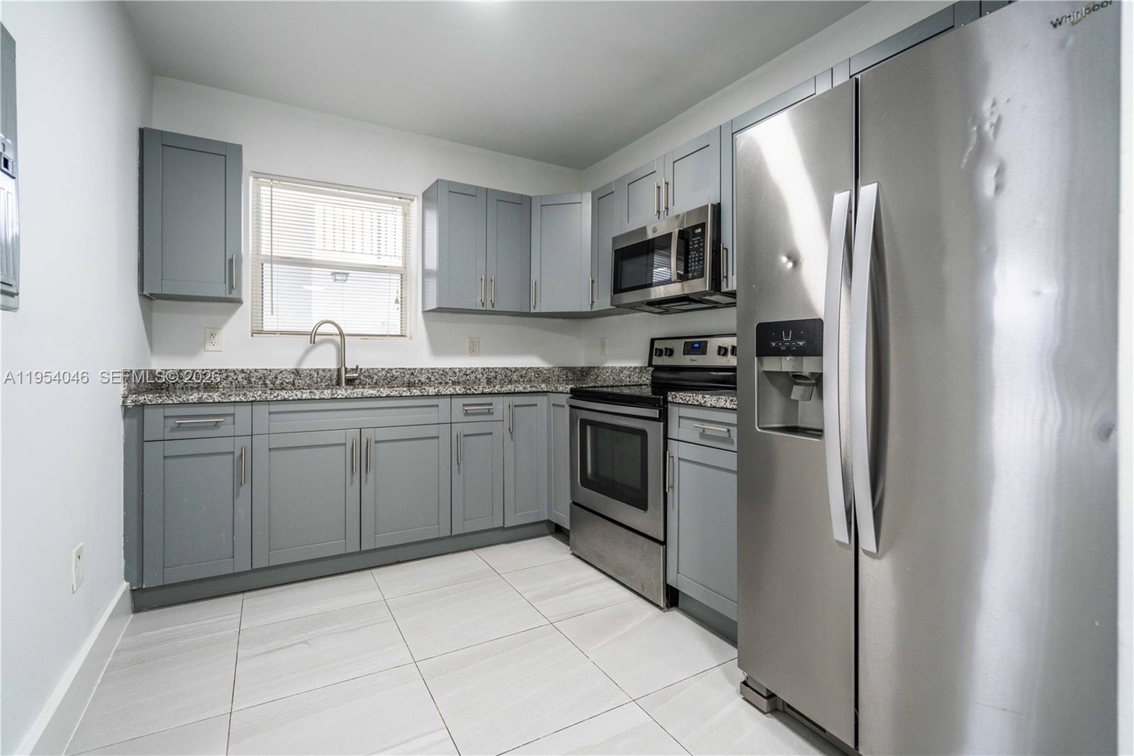 465 Northeast 59th Street, Unit 12 Miami, FL 33137 - Photo 10 of 17 a kitchen with stainless steel appliances granite countertop a refrigerator sink and stove