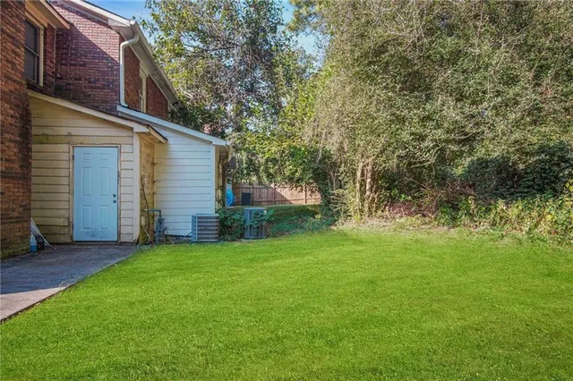 a view of a backyard with potted plants and large tree
