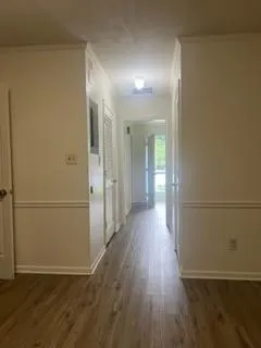 a view of a hallway with wooden floor