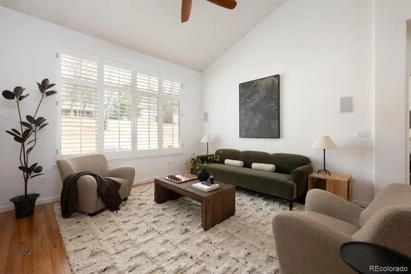 a living room with furniture ceiling fan and a window