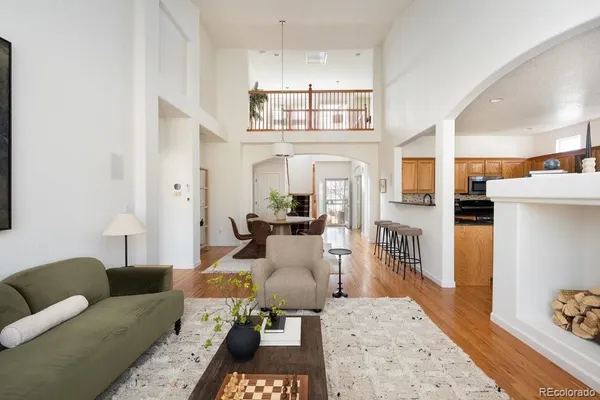 a living room with furniture a rug and kitchen view