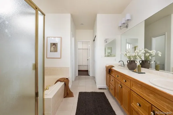 a spacious bathroom with a double vanity sink a mirror and shower