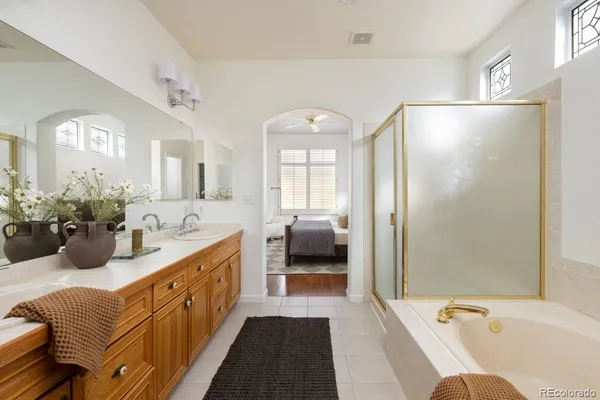 a bathroom with a tub a sink and mirror