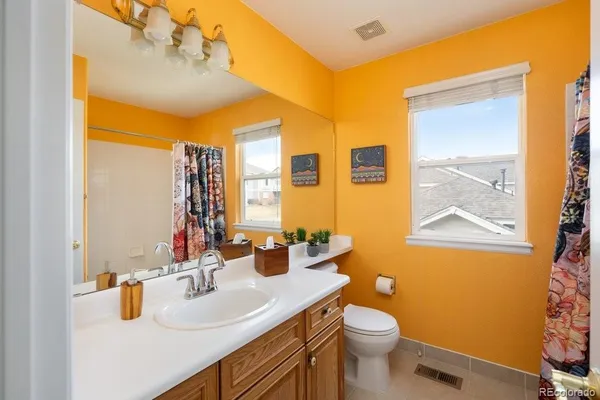 a bathroom with a granite countertop sink toilet and mirror
