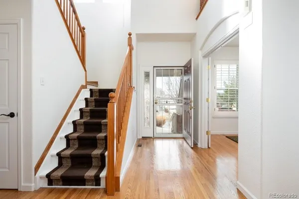 a view of front door with wooden floor and stairs