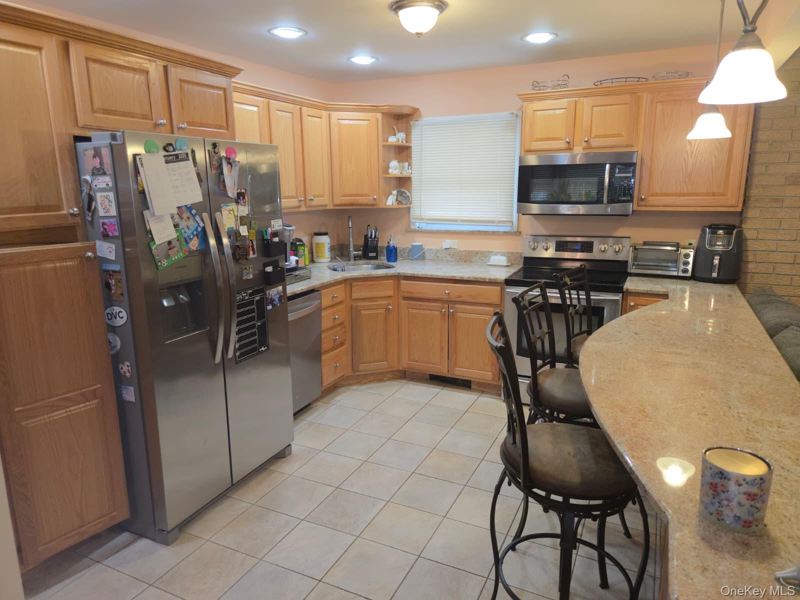 131 Ethel Street Valley Stream, NY 11580 - Photo 5 of 18 a kitchen with stainless steel appliances granite countertop a refrigerator a stove a sink a dining table and chairs