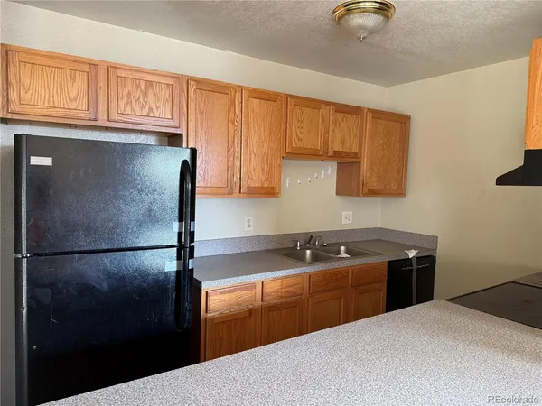 a kitchen with stainless steel appliances granite countertop a sink refrigerator and cabinets