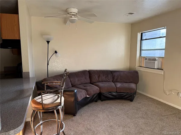 a living room with furniture a ceiling fan and a window