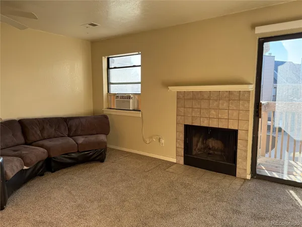 a living room with furniture a fireplace and a window