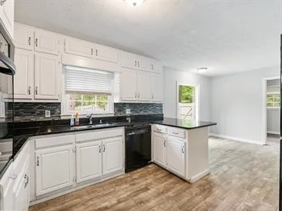 a kitchen with granite countertop white cabinets and white appliances