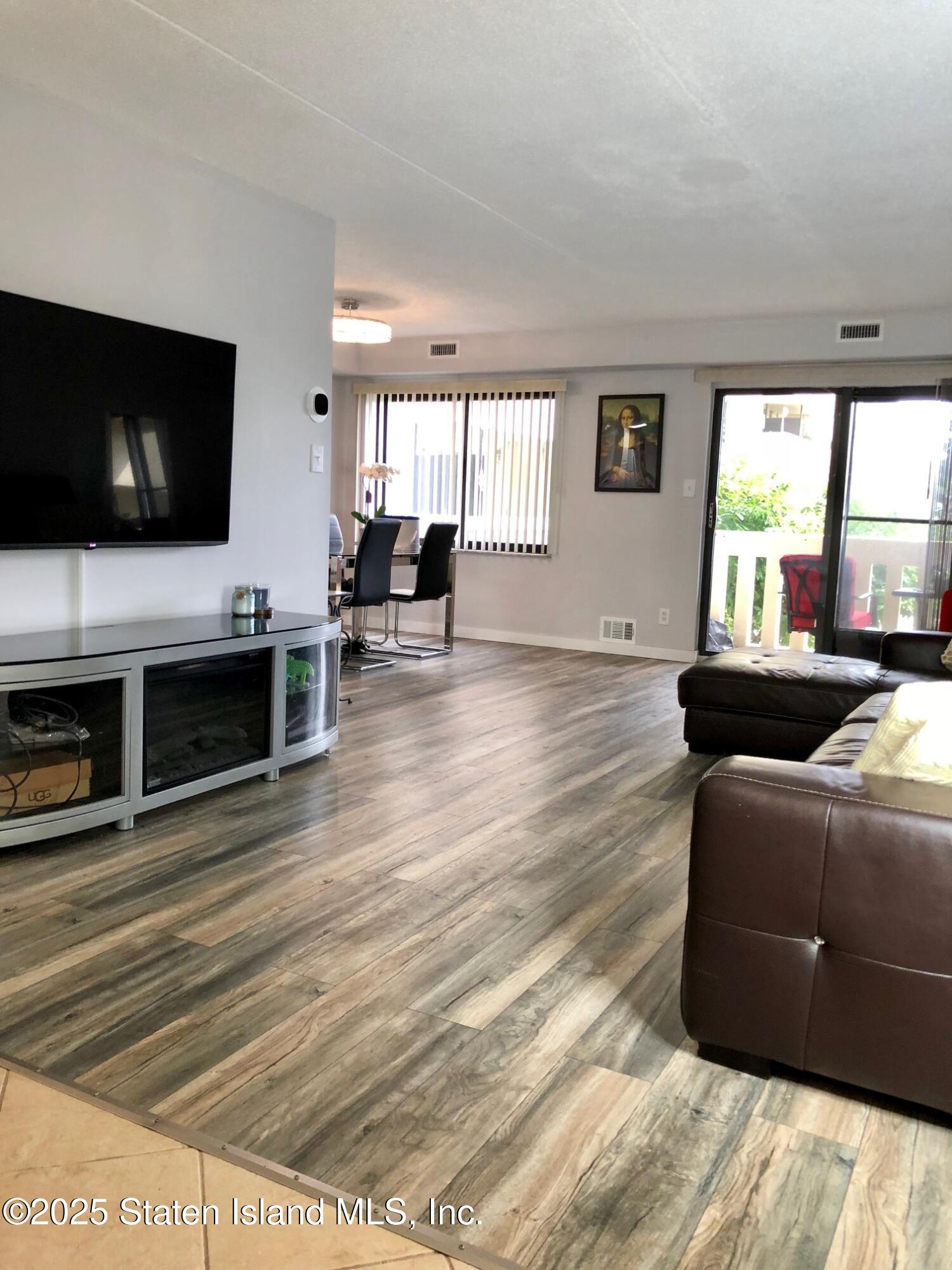 11 Windham Loop, Unit 2DD Staten Island, NY 10314 - Photo 3 of 27 a living room with furniture and a flat screen tv