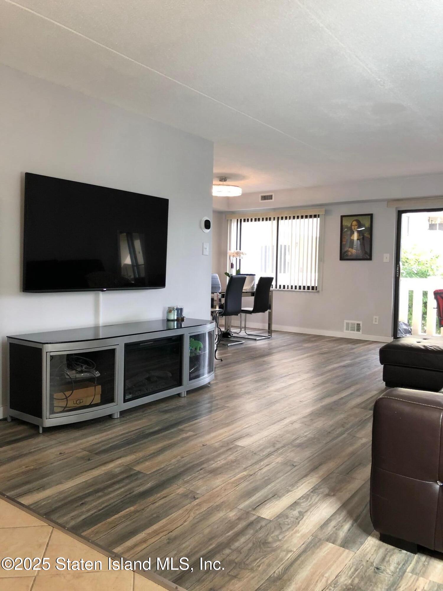 11 Windham Loop, Unit 2DD Staten Island, NY 10314 - Photo 5 of 27 a living room with furniture and a flat screen tv