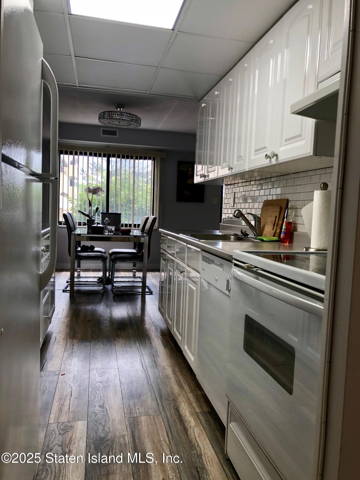 11 Windham Loop, Unit 2DD Staten Island, NY 10314 - Photo 7 of 27 a kitchen with sink cabinets and wooden floor
